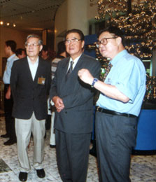 2000年8月24日,第九届全国人大常委会委员长李鹏和出席全国人大常委会的400多名委员视察中国科技馆,李鹏专门听取了科学家对于人类基因组计划的介绍。图为李鹏在人大副委员长、中国科协主席周光召(左)和中国科技馆馆长王渝生的陪同下观看介绍人类基因计划的展板。