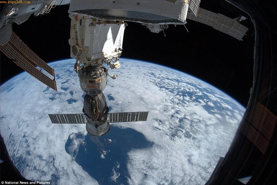 这是太空里一个独一无二的奇幻时刻。从“圆顶(Cupola)”观测舱向外看，可以看到将要带指令官惠洛克回家的那艘飞船。从下面裂开的云缝里，可以看到加拉帕哥斯群岛。