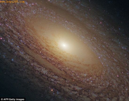 螺旋星系NGC 2841。一个巨大的尘埃带盘内散布着大量恒星，所环绕的明亮星光尖角便是这个星系的中心。
