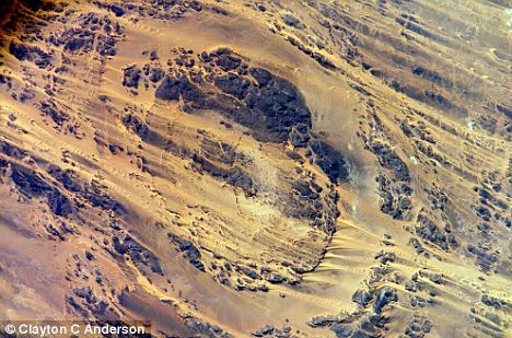 乍得撒哈拉沙漠的奥隆加陨坑，直径11英里(约合17公里)，由3.45亿年前的陨石撞击形成。这幅照片由宇航员克莱顿-安德森拍摄