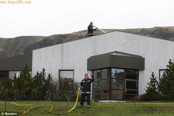 清洗：冰岛消防部门的工作人员用高压水枪清洗居民家的房顶